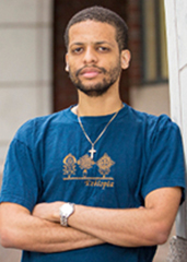 Jelani Nelson posing next to a wall